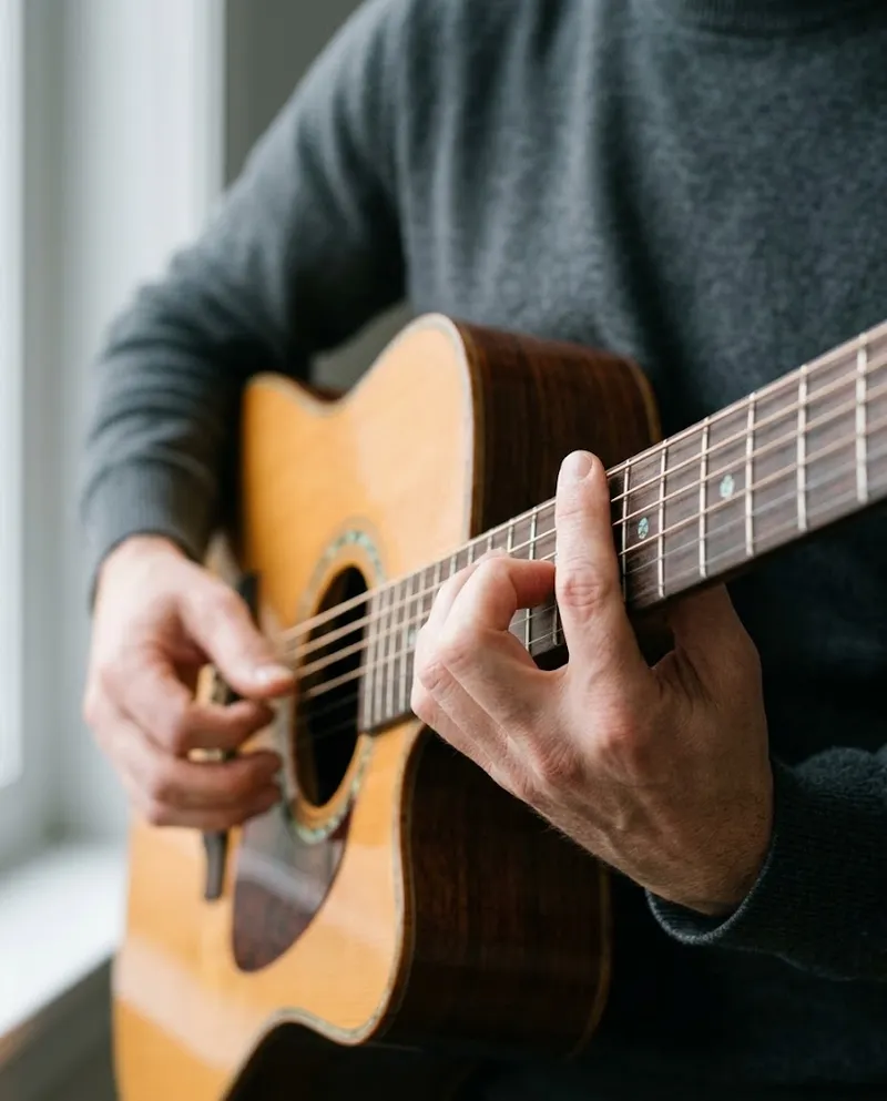 Mãos de um guitarrista no braço de uma guitarra acústica